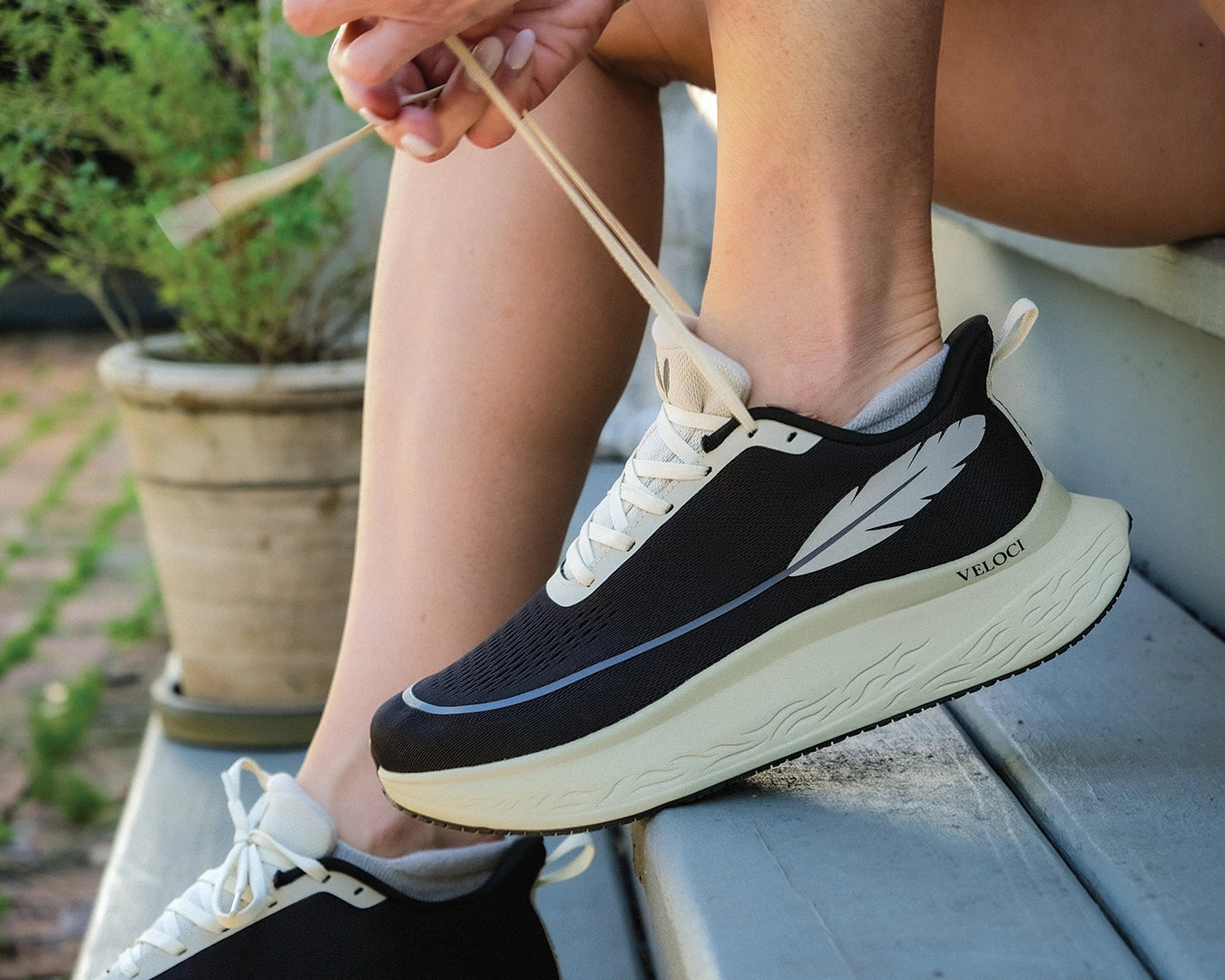Veloci Ascent running shoe in black with cream midsole, outdoor side profile showing the supportive foam, wide toe box and breathable mesh upper