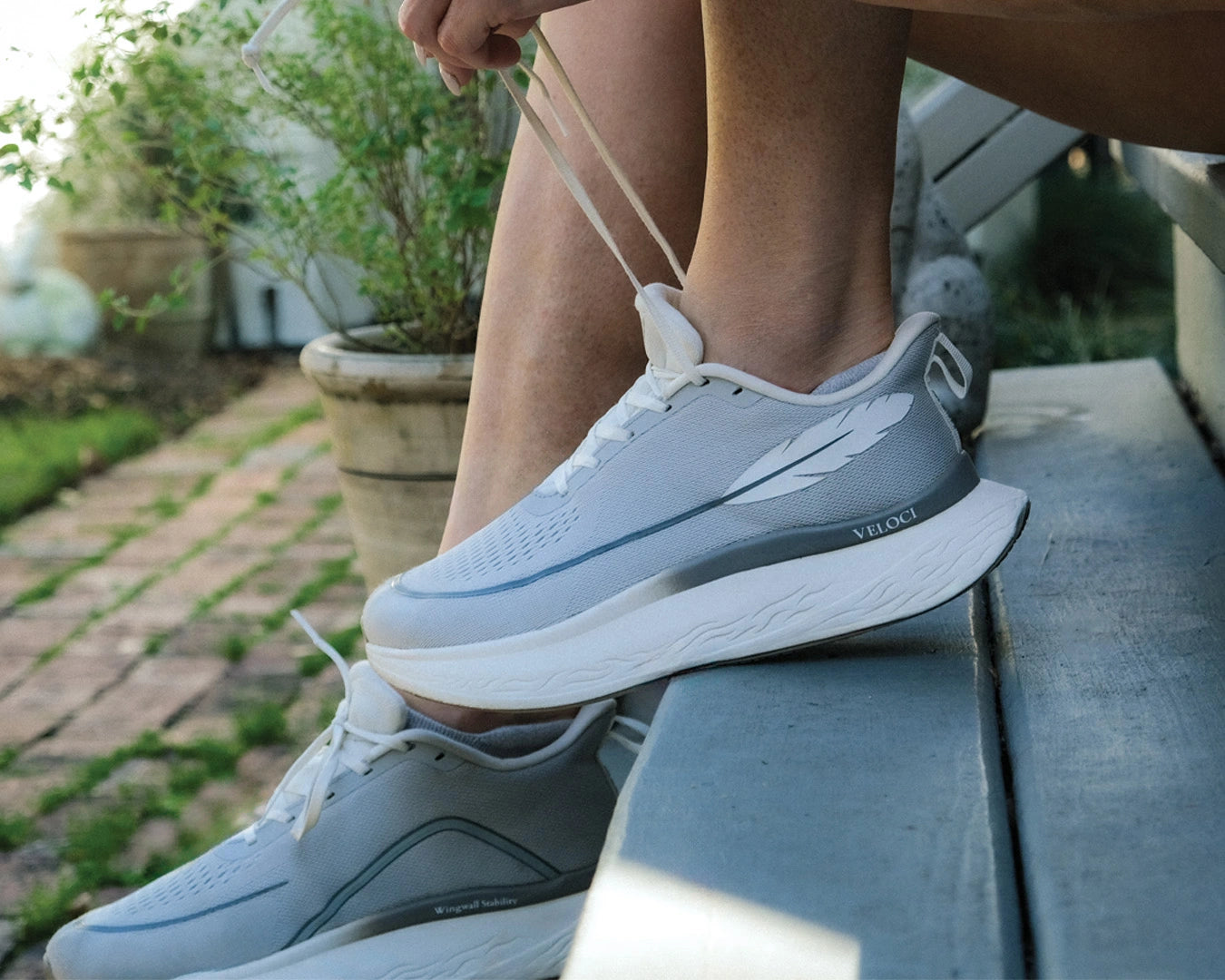 Veloci Mesa stability running shoe in gray with white midsole, outdoor side profile showing the wide toe box, supportive foam, and breathable upper